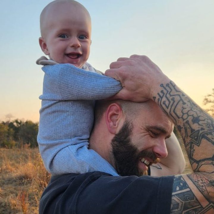 Guy Carosin with his son Codi on his shoulders at sunset